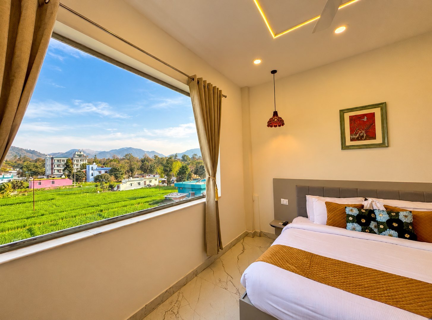 Mountain-view guest room overlooking green fields and Rishikesh hills